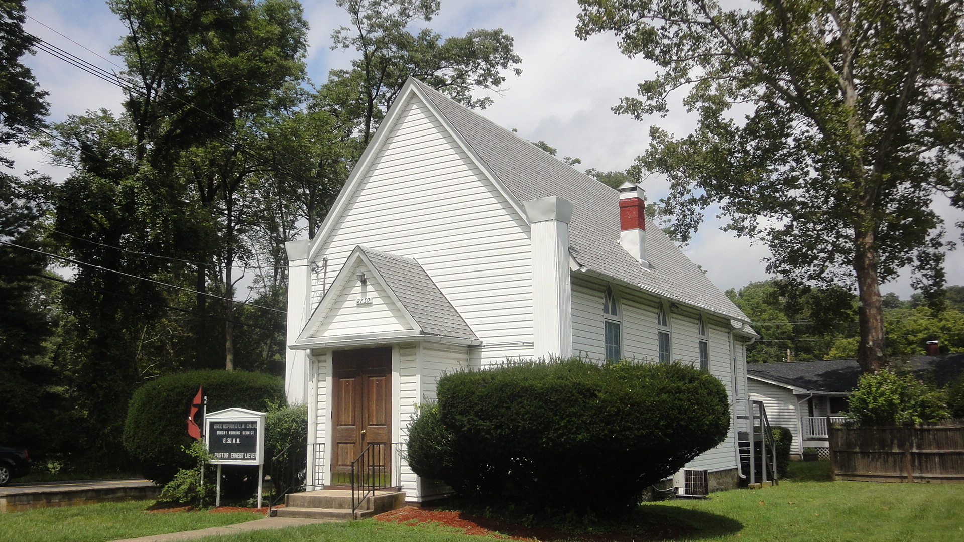 Church exterior with entrance and welcome sign.